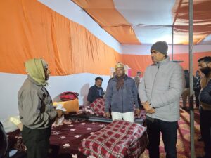 रेन बसेरा में रात्रि विश्राम कर रहे निराश्रित लोगों से बातचीत करते डीएम सी पी सिंह 